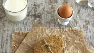 桌上的饼干，软煮鸡蛋，和一杯牛<strong>奶</strong>在乡村的木制桌子上。 道具4K..